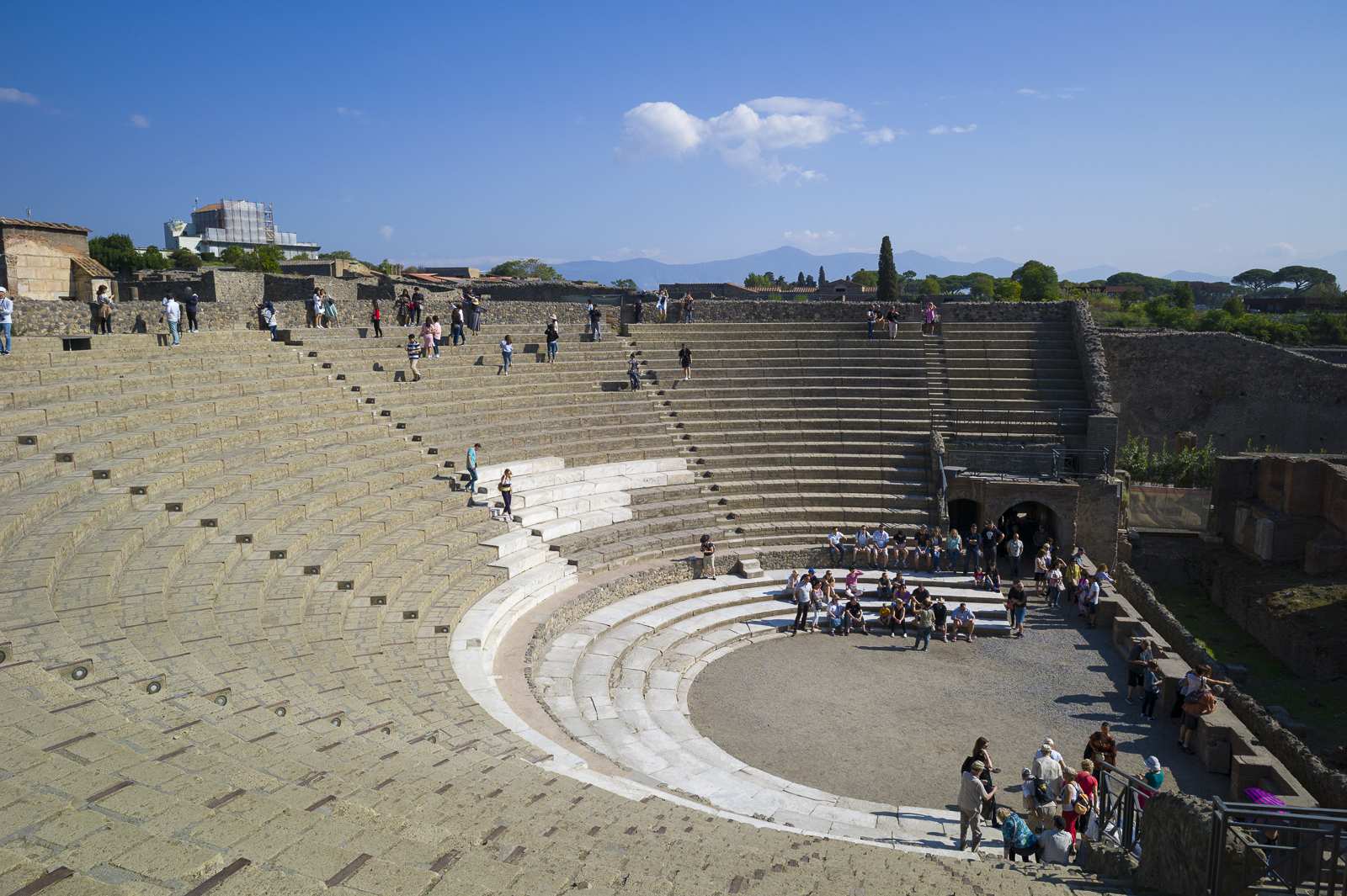 Marches du grand théâtre de Pompéi avec des visiteurs en train d'explorer