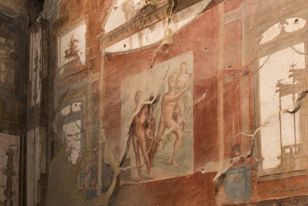 Roman fresco with mythological scene of nude figures on red background.