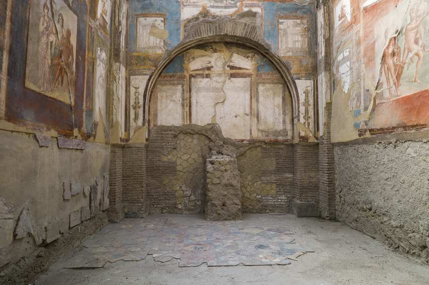 Room decorated with Roman frescoes and arched niche in Herculaneum Archaeological Park