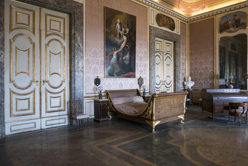 Royal bedroom with antique bed and elegant furnishings at the Royal Palace of Caserta