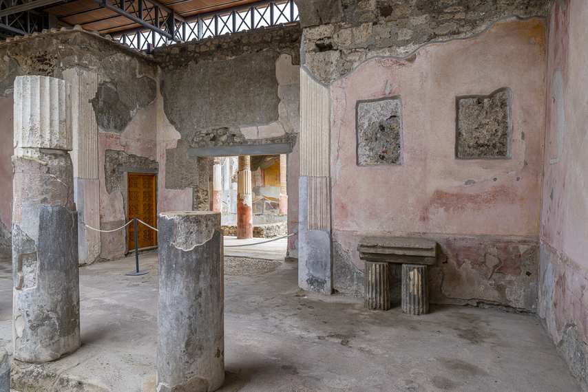 Interior of the House of the Dioscuri in Pompeii with columns and remains of frescoes