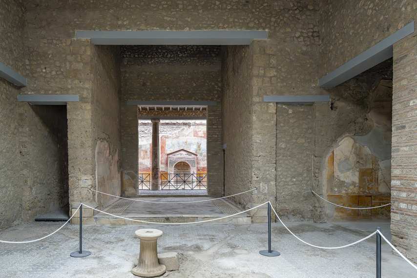 Interior view of the House of the Small Fountain with decorated fountain in the background, in Pompeii.