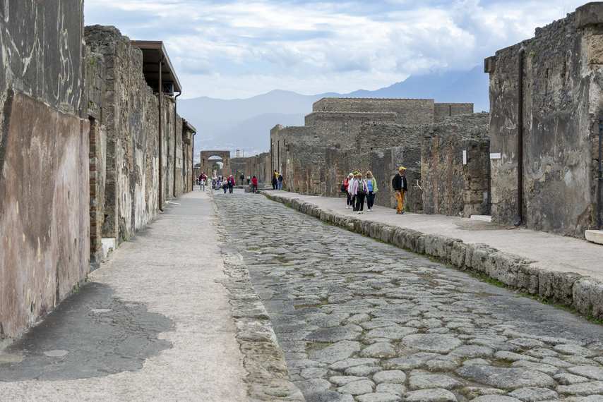 Roman road with lava paving stones in Pompeii, overlooking Vesuvius