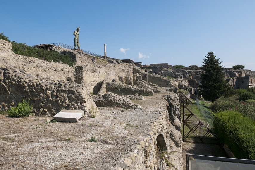 Glimpse of the ruins of the Temple of Venus in Pompeii with statue and columns