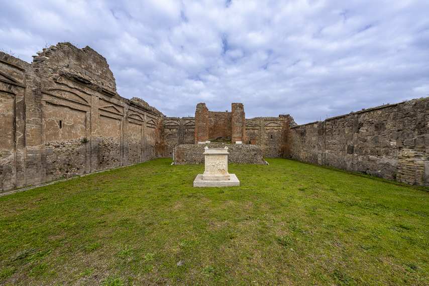 Marble altar at the center of the Temple of Genius Augusti in Pompeii, surrounded by ruins