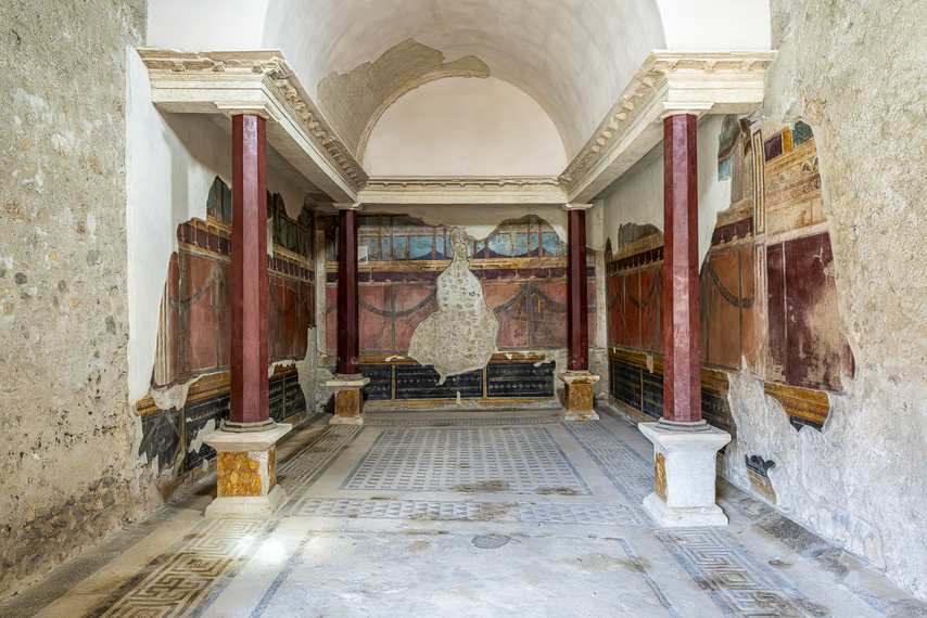 Triclinium with red columns and third style frescoes in the House of the Silver Wedding in Pompeii