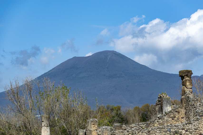 Mount Vesuvius in the background with ruins of ancient Pompeii in the foreground